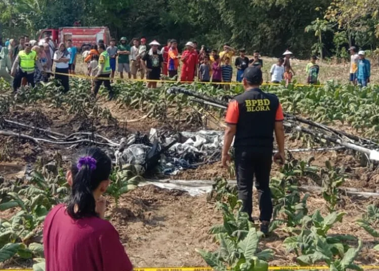 Warga melihat bekas pesawat latih TNI AU yang terbakar setelah melakukan pendaratan darurat di areal persawahan yang ada di Desa Sarimulyo, Kecamatan Ngawen, Kabupaten Blora, Minggu, 6 September 2026. (BPBD Blora/Lingkarjateng.id)