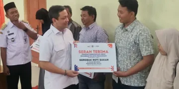 Wali Kota Pekalongan, Achmad Afzan Arslan Djunaid, menyerahkan bantuan gerobak secara simbolis kepada salah satu penerima dalam kegiatan Tasharuf Program Pemberdayaan UMKM 2026 yang digelar Lazismu Kota Pekalongan di Gedung Dakwah Muhammadiyah, Kamis, 3 September 2026. (Fahri Alakbar/Lingkarjateng.id)