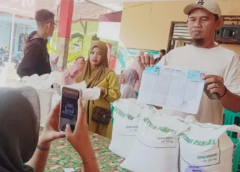 Warga Kota Pekalongan menerima bantuan sosial berupa beras dalam kegiatan penyaluran bantuan beberapa waktu lalu. (Fahri Akbar/Lingkarjateng.id)