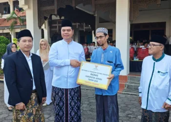 Bupati Jepara, Witiarso Utomo, secara simbolis menyerahkan bantuan usaha program Marbot Berdaya kepada penerima manfaat usai apel HSN di Halaman Setda Jepara, Kamis, 22 Oktober 2026. (Tomi Budianto/Lingkarjateng.id)