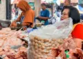 Pedagang daging ayam di komplek Pasar Raya 1 Salatiga saat melayani pembeli, belum lama ini. (Angga Rosa/Lingkarjateng.id)