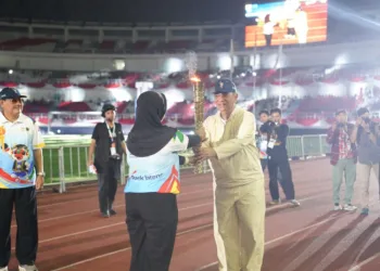 Suami Bupati Kendal, Murdoko, yang merupakan mantan Ketua KONI Jawa Tengah menyerahkan api obor dalam pembukaan Porprov Jateng di Stadion Jatidiri, Kota Semarang, Minggu malam, 25 Oktober 2026. (Dok. Media Bupati Kendal/Lingkarjateng.id)