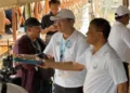 Momen Gubernur Jawa Tengah Ahmad Luthfi membagikan gorengan kepada warga saat mendampingi kunjungan kerja Menteri Koordinator Bidang Infrastruktur dan Pembangunan Kewilayahan Agus Harimurti Yudhoyono (AHY) di Desa Timbulsloko, Kabupaten Demak, Senin, 19 Oktober 2026. (Dok. Humas Pemprov Jateng/Lingkarjateng.id)