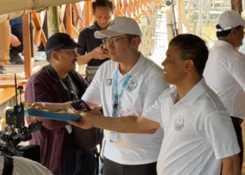 Momen Gubernur Jawa Tengah Ahmad Luthfi membagikan gorengan kepada warga saat mendampingi kunjungan kerja Menteri Koordinator Bidang Infrastruktur dan Pembangunan Kewilayahan Agus Harimurti Yudhoyono (AHY) di Desa Timbulsloko, Kabupaten Demak, Senin, 19 Oktober 2026. (Dok. Humas Pemprov Jateng/Lingkarjateng.id)